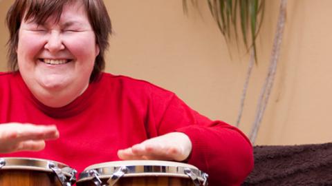 Banner Red de atención a personas adultas con discapacidad Mujer tocando un instrumento de percusión