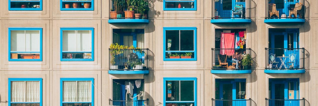 Fachada de un bloque de viviendas con ventanas azules