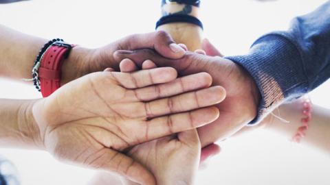 Banner red de atención social a personas con enfermedad mental Conjunto de personas uniendo sus manos en un gesto de unión